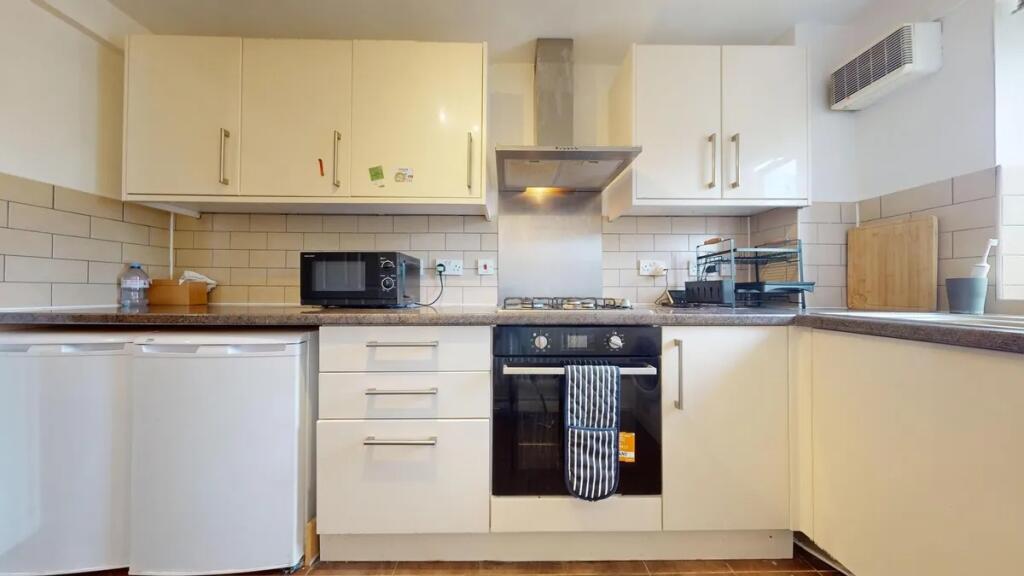 Bright and modern kitchen featuring clean white...