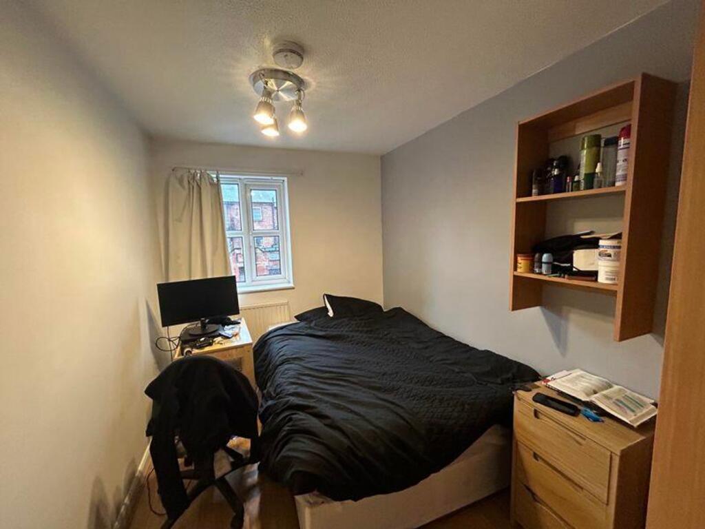 A cozy double bedroom with good lighting and a ...