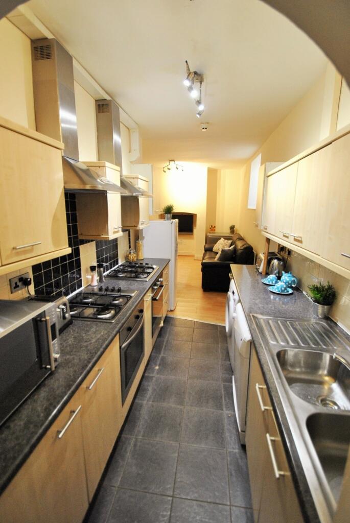 A modern kitchen featuring sleek cabinetry, amp...