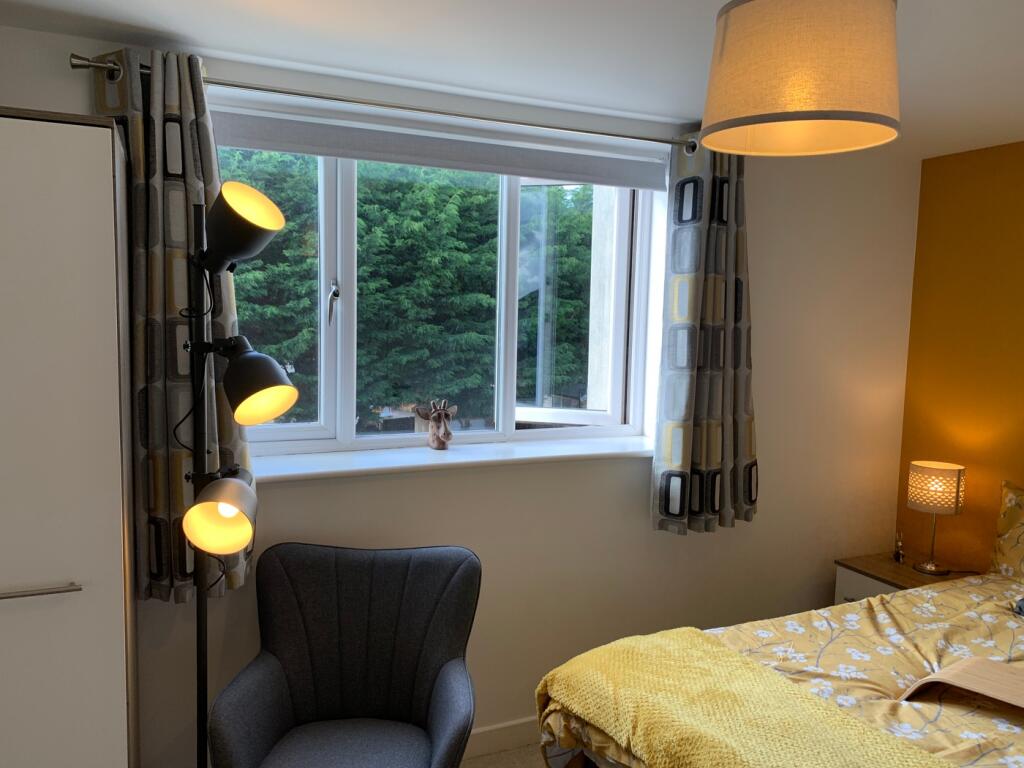A cozy and well-lit double bedroom featuring a ...
