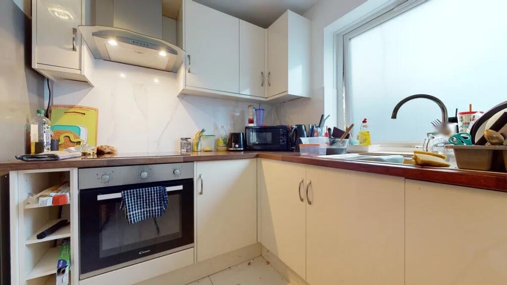 A bright kitchen with modern white cabinetry an...