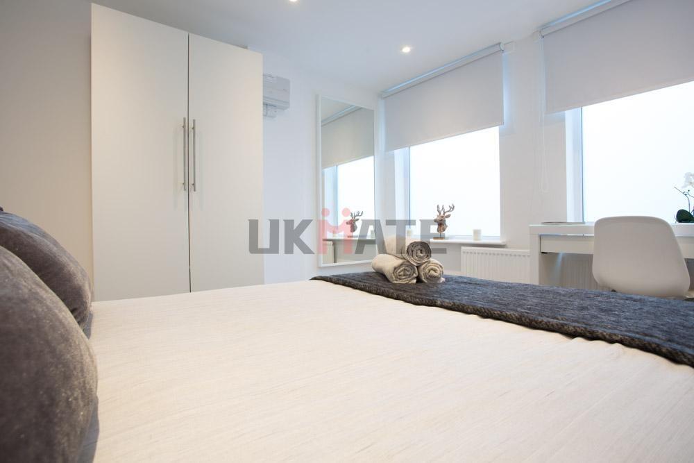 A bright and modern bedroom featuring a comfort...
