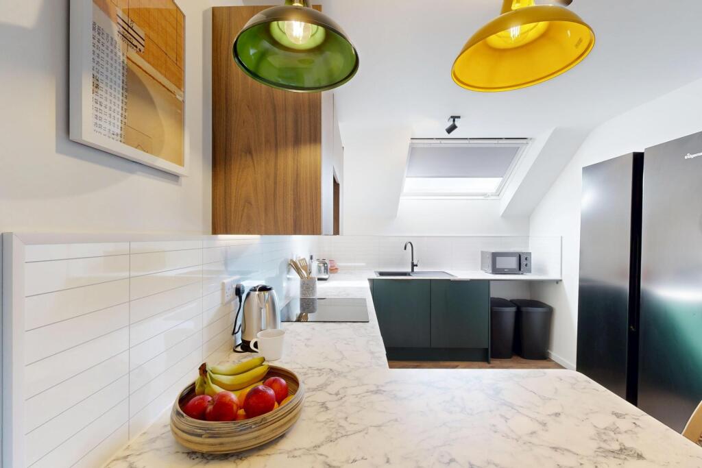 Bright, modern kitchen with marble-effect workt...
