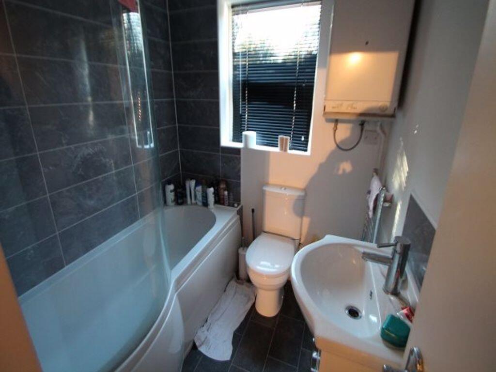 A clean and modern bathroom featuring a bathtub...