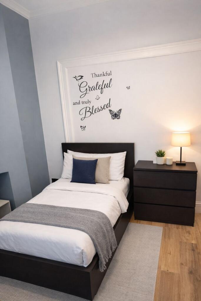 Bright, neatly styled single bedroom with a com...