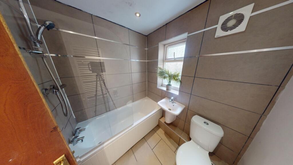 A modern and clean bathroom featuring a bathtub...