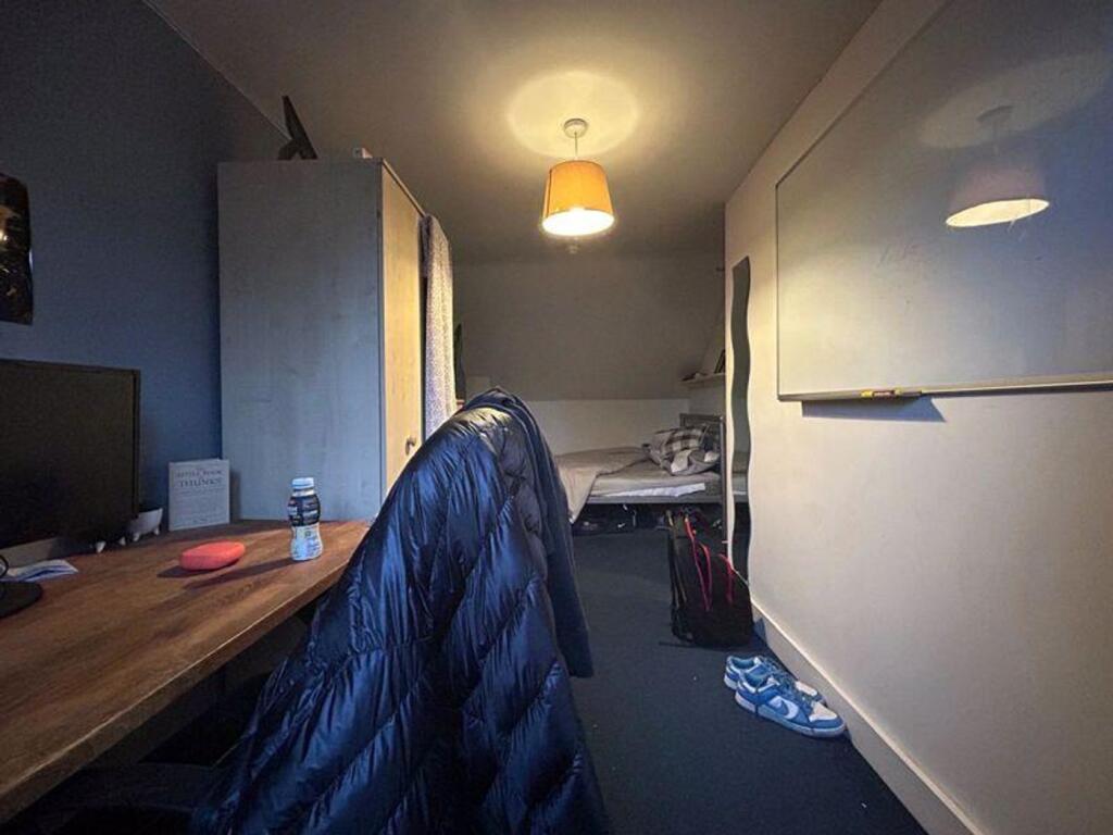 A cozy double bedroom with a functional workspa...