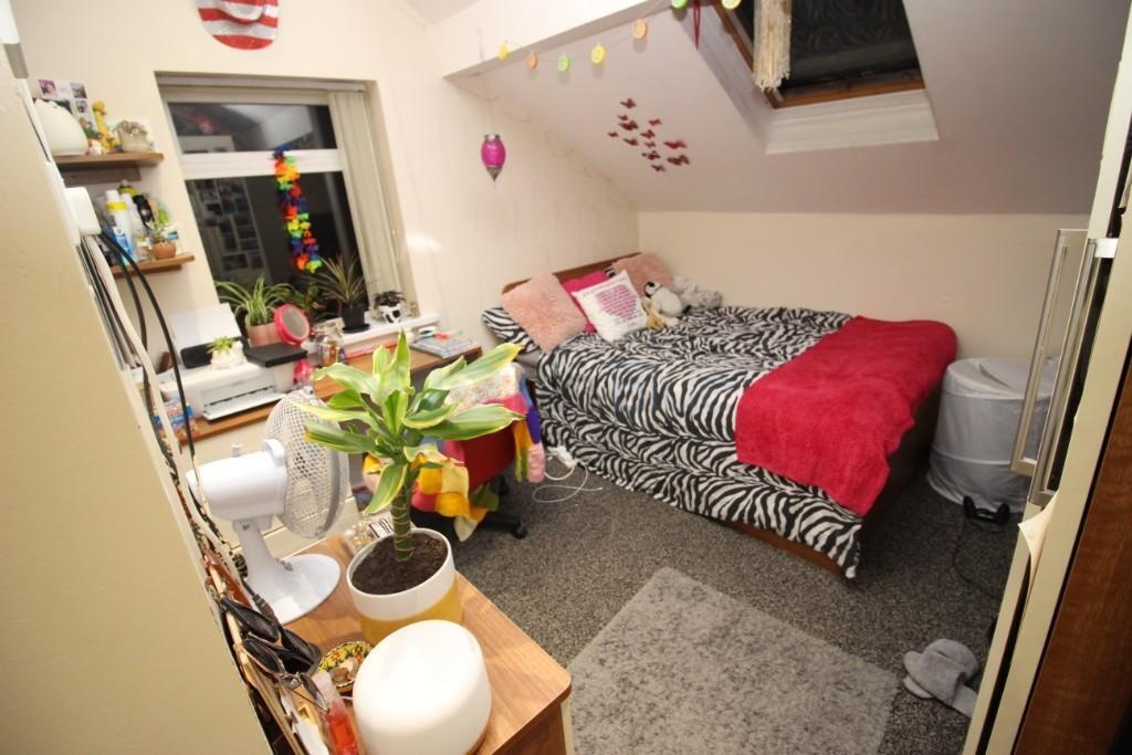 A cozy single bedroom featuring a comfortable b...