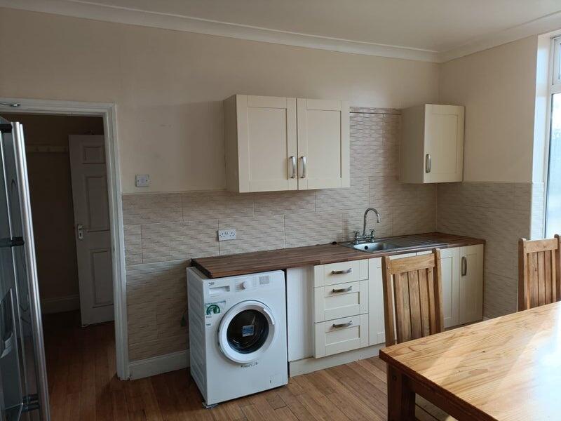 A bright and tidy kitchen featuring wooden coun...