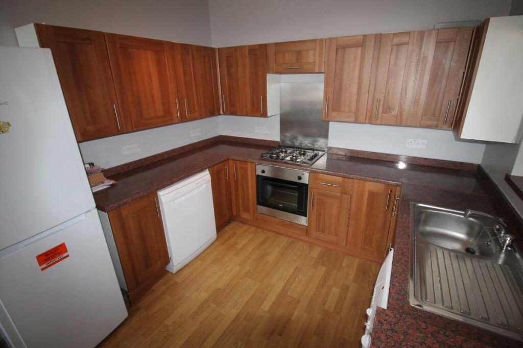 Bright and modern kitchen featuring ample woode...