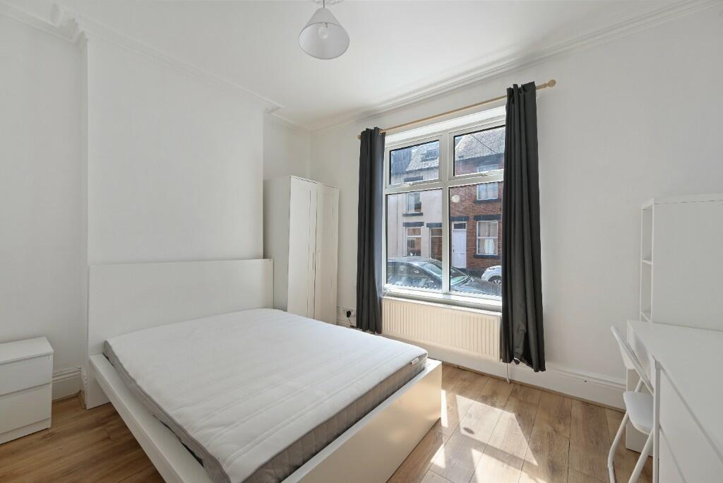 A bright and clean double bedroom featuring a l...