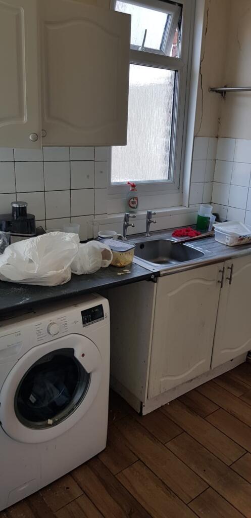 Bright kitchen featuring a washing machine, sin...