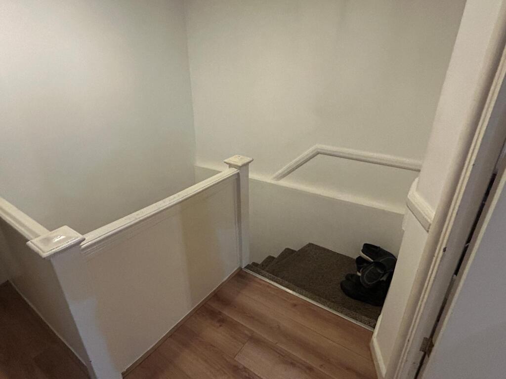Well-maintained staircase and landing with ligh...