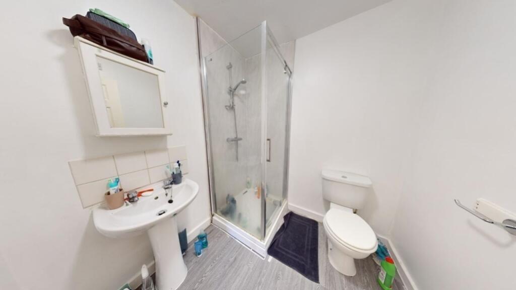 A modern bathroom suite featuring a clear glass...