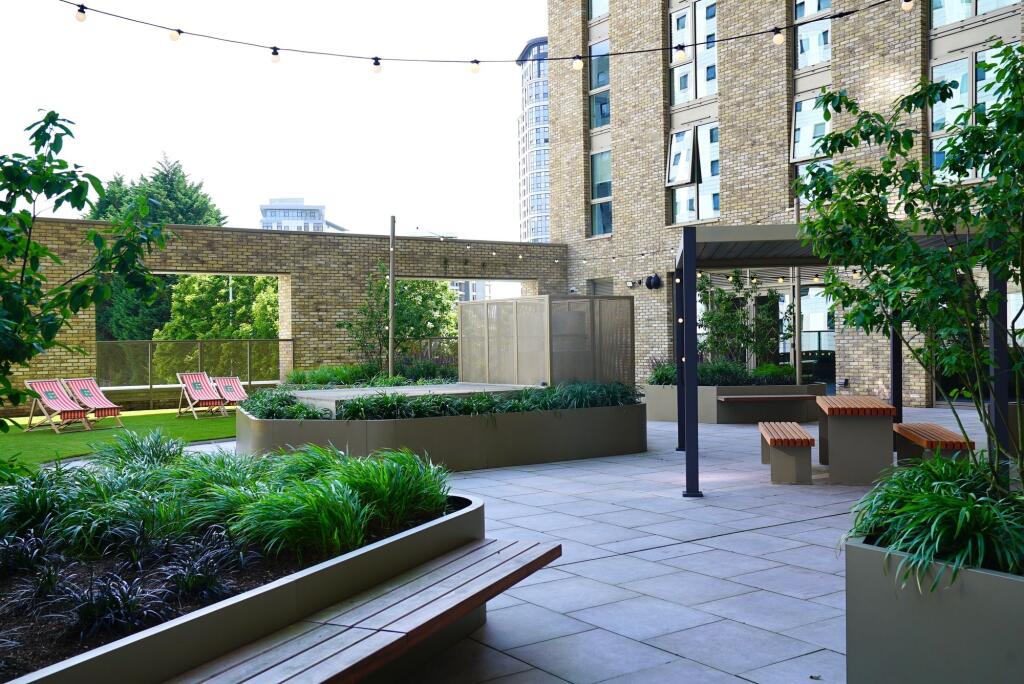 A modern outdoor garden area featuring lush gre...