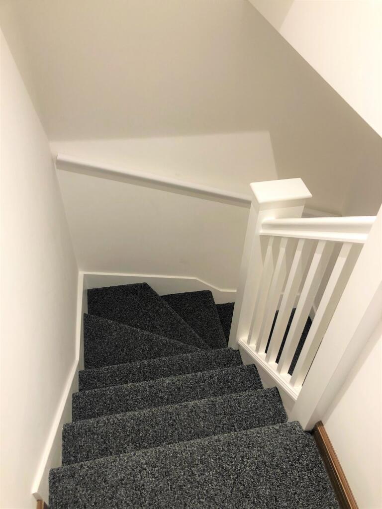 A clean, well-maintained staircase with grey ca...