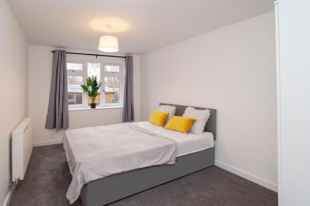 A clean and inviting double bedroom with large ...