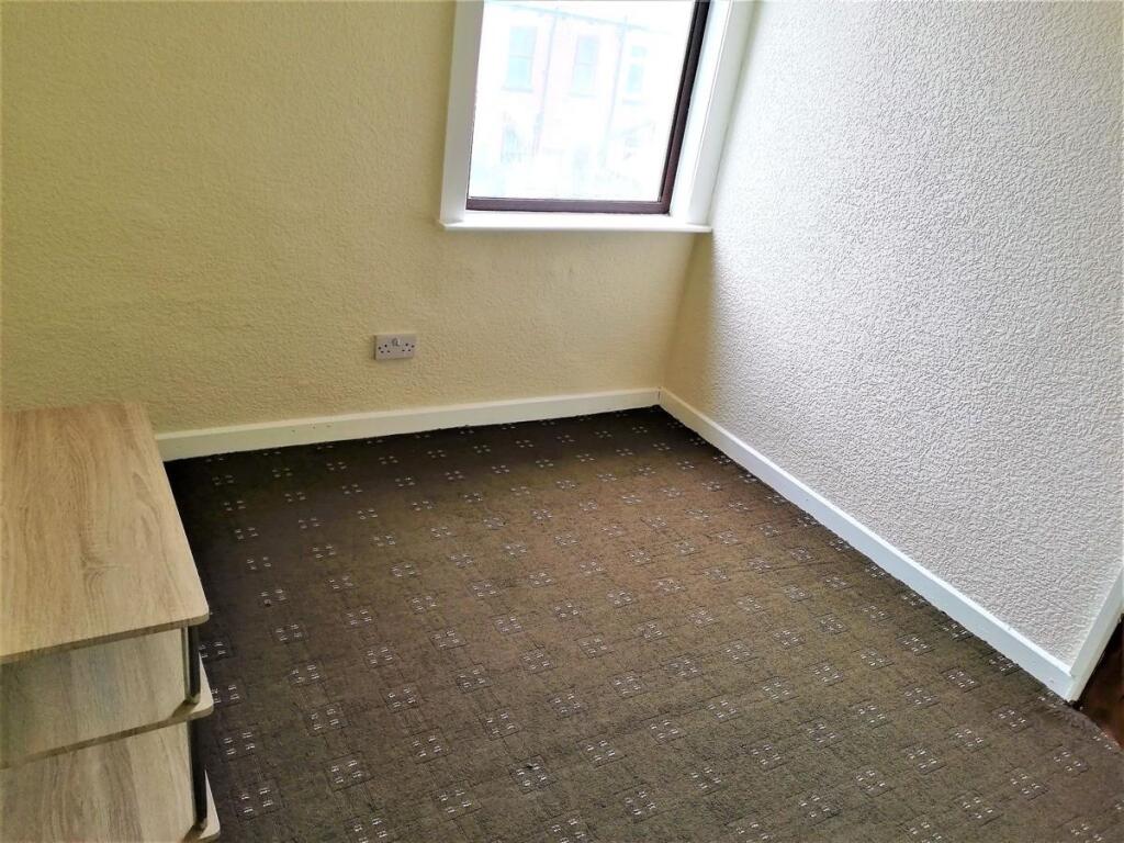 Small, tidy bedroom with neutral walls, a front...
