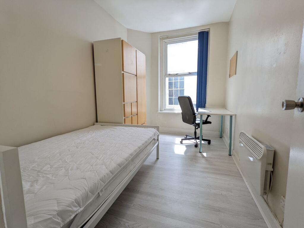 Bright single bedroom with a large window, simp...