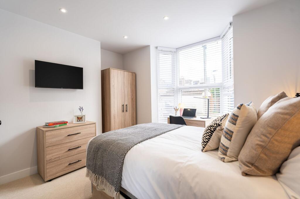 Bright, modern bedroom with large windows and a...