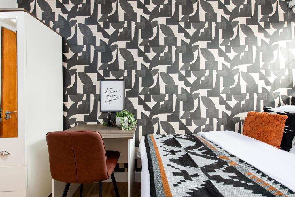 A stylish double bedroom featuring a bold patte...