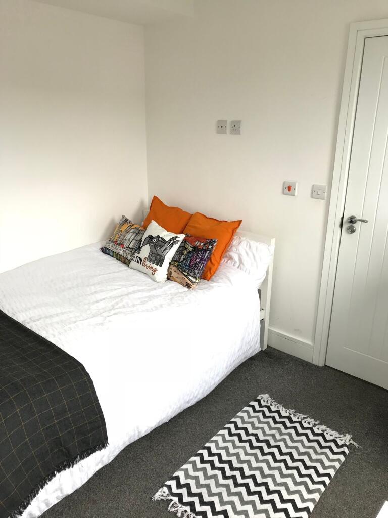 This cozy double bedroom features a comfortable...