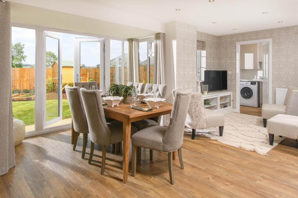 Open-plan kitchen with integrated appliances, dining area &amp; family room with French doors leading on