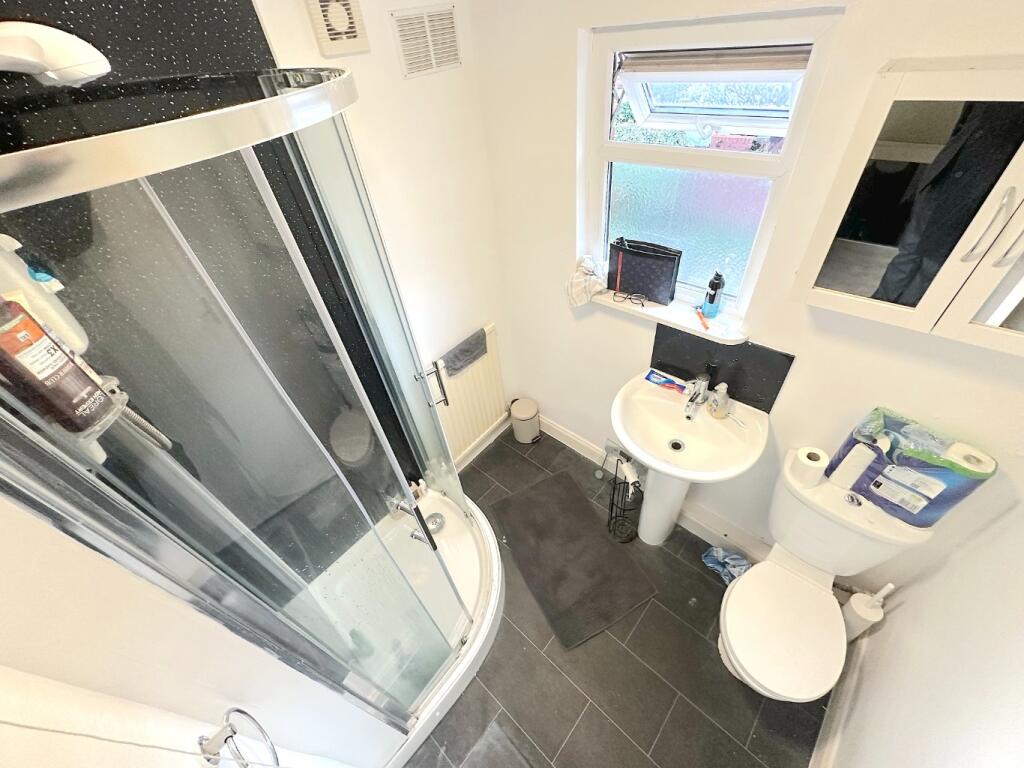 Bright, modern bathroom with a curved glass sho...