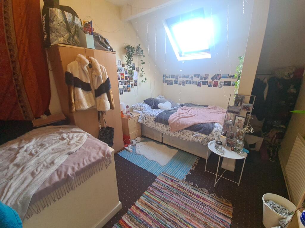 Cozy single bedroom featuring a bright skylight...
