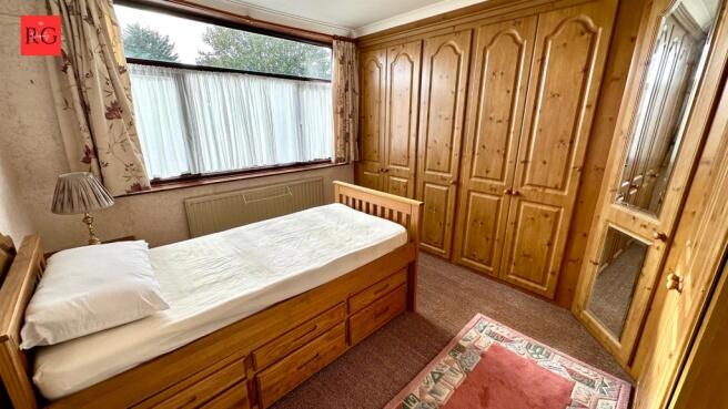 Cozy single bedroom featuring a large window al...