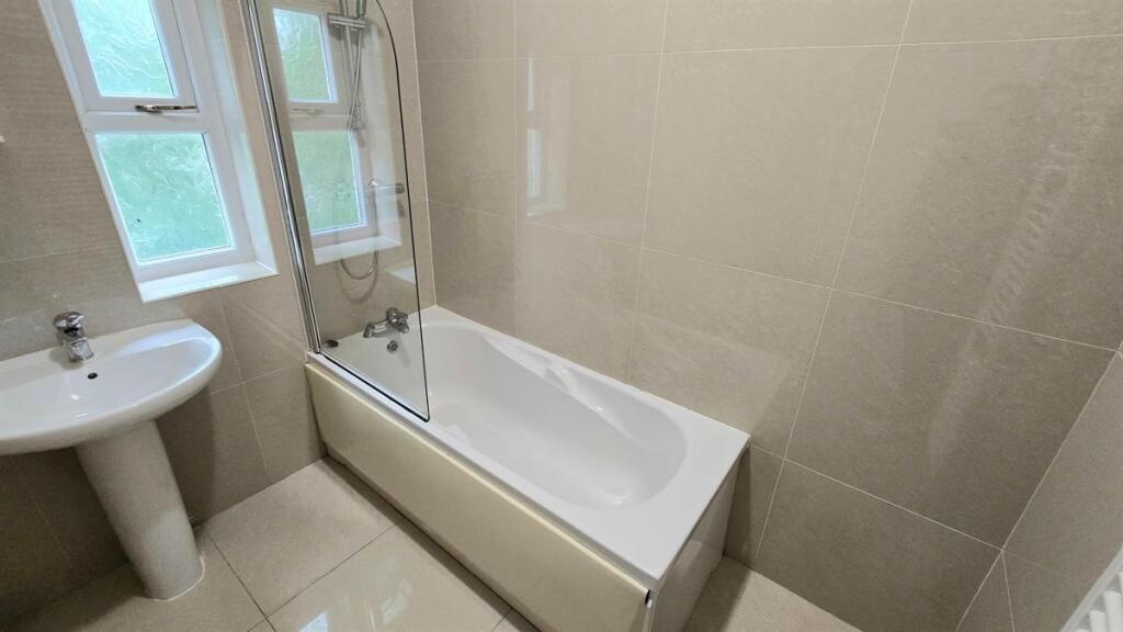 Bright, modern bathroom with a clean white bath...