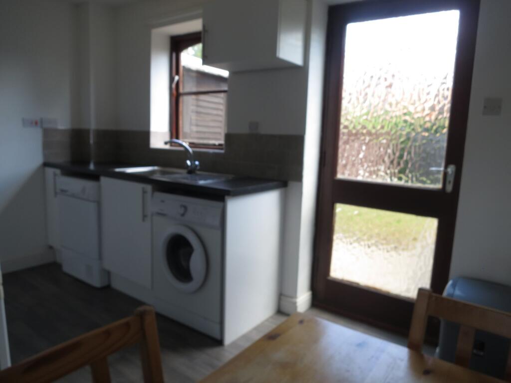 A compact kitchen area featuring a washing mach...