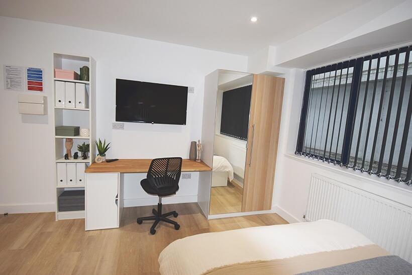 A bright and tidy single bedroom furnished with...