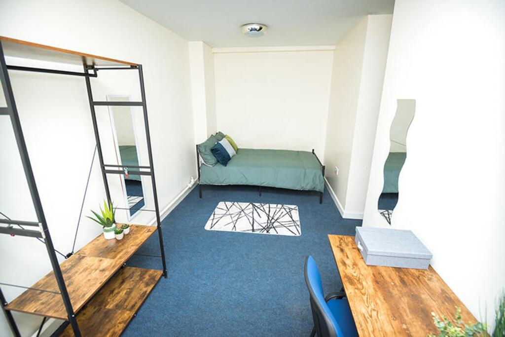Spacious double bedroom featuring a cozy bed, a...