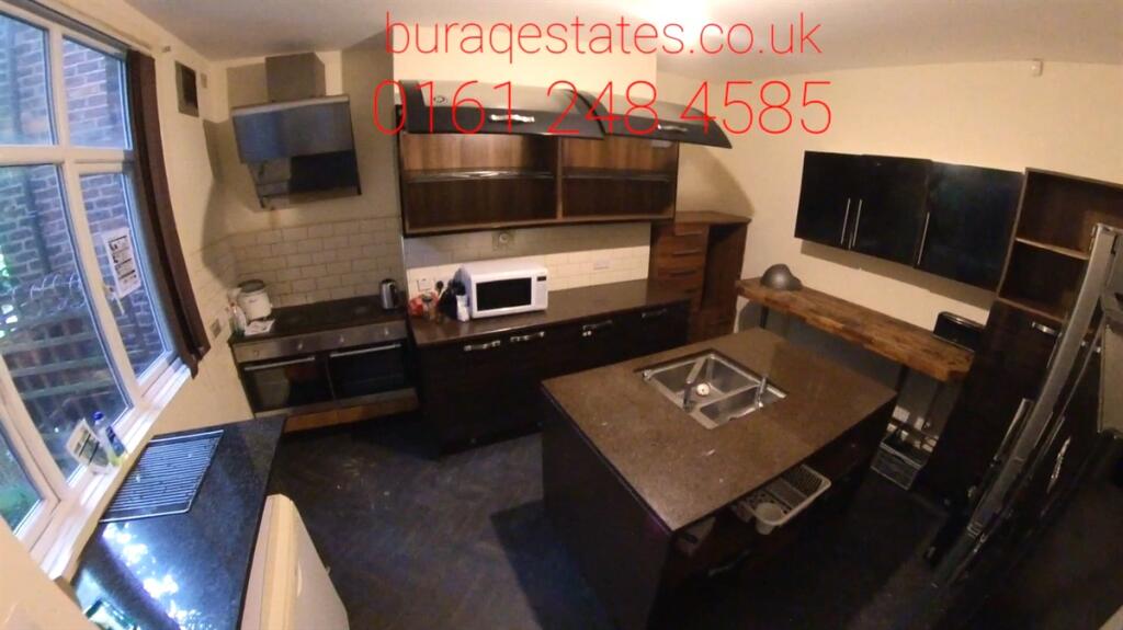 Modern kitchen with dark cabinetry and a centra...