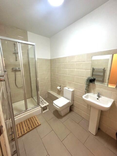 A clean and modern bathroom featuring a glass-e...