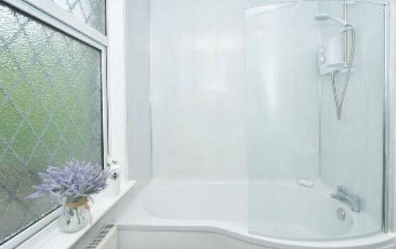 Bright and clean bathroom featuring a large bat...