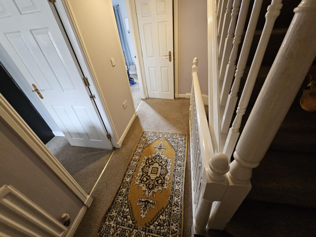 A neat and welcoming hallway featuring a patter...