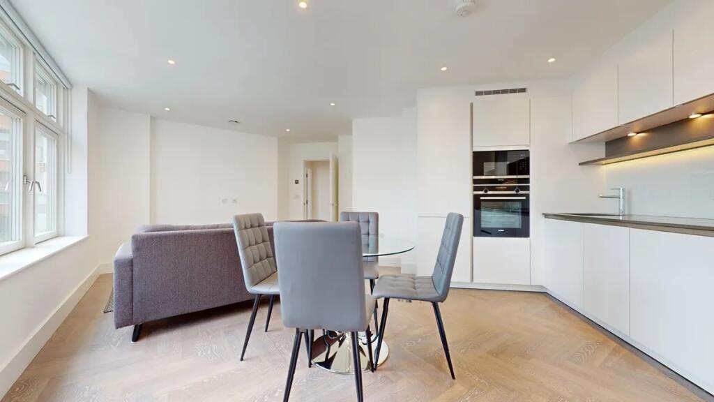 Bright and modern living room with a sleek kitc...