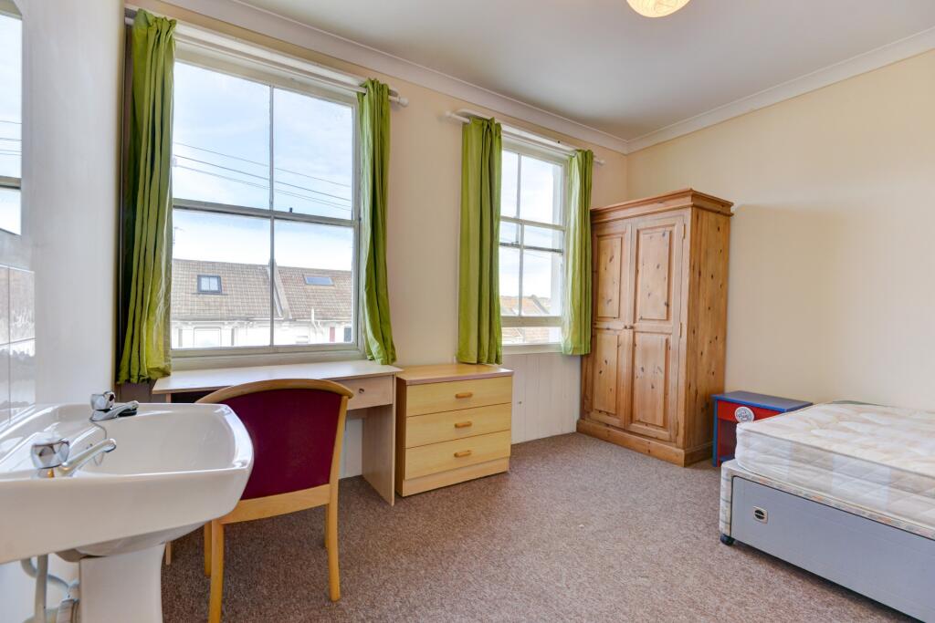 Bright and tidy bedroom featuring a large windo...