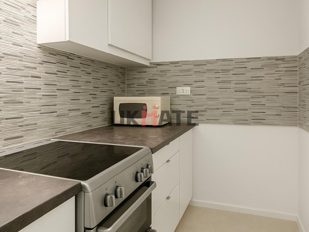 Modern kitchen area featuring a sleek counterto...