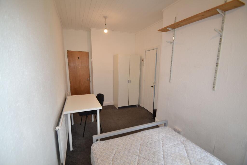 A compact single bedroom featuring a simple des...