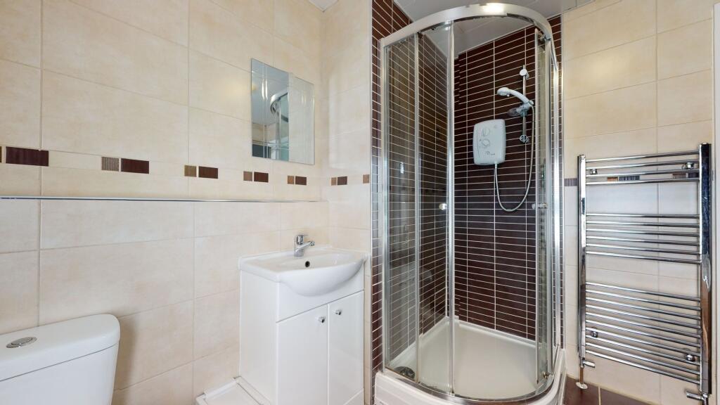 A clean and modern bathroom featuring a corner ...