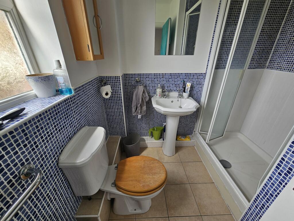 A modern bathroom featuring a tiled shower encl...