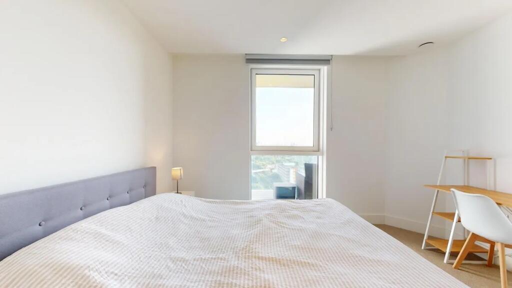 A bright and airy master bedroom featuring a co...