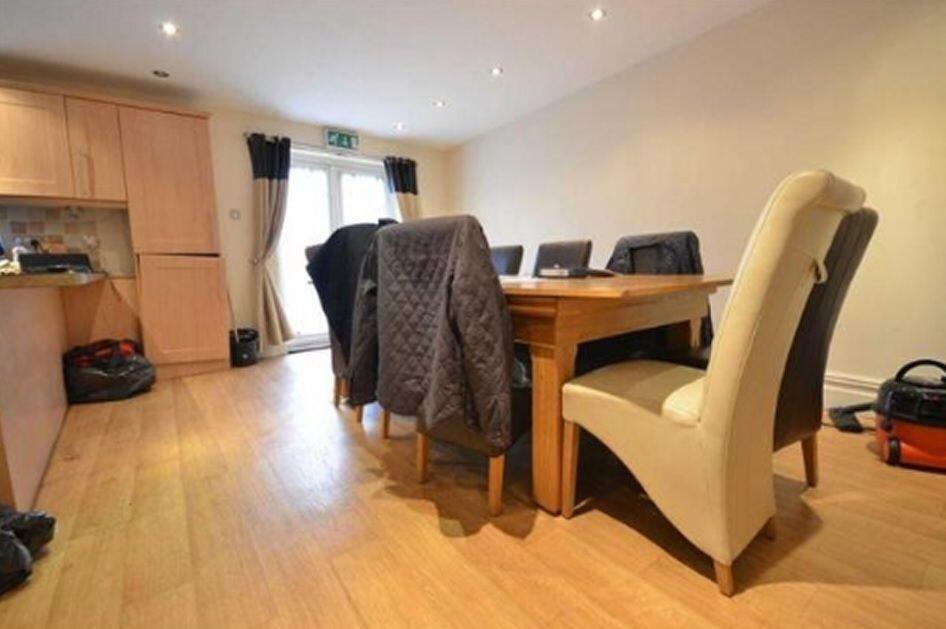 A bright kitchen and dining area featuring wood...