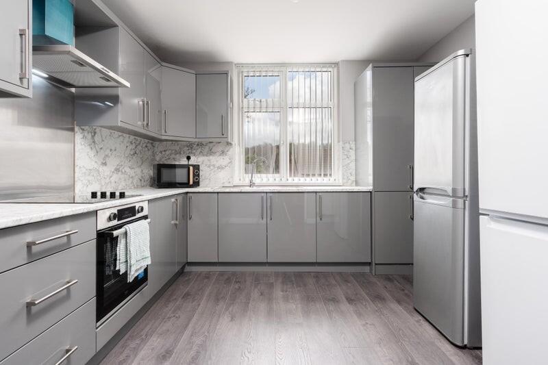 Modern kitchen featuring sleek grey cabinets an...