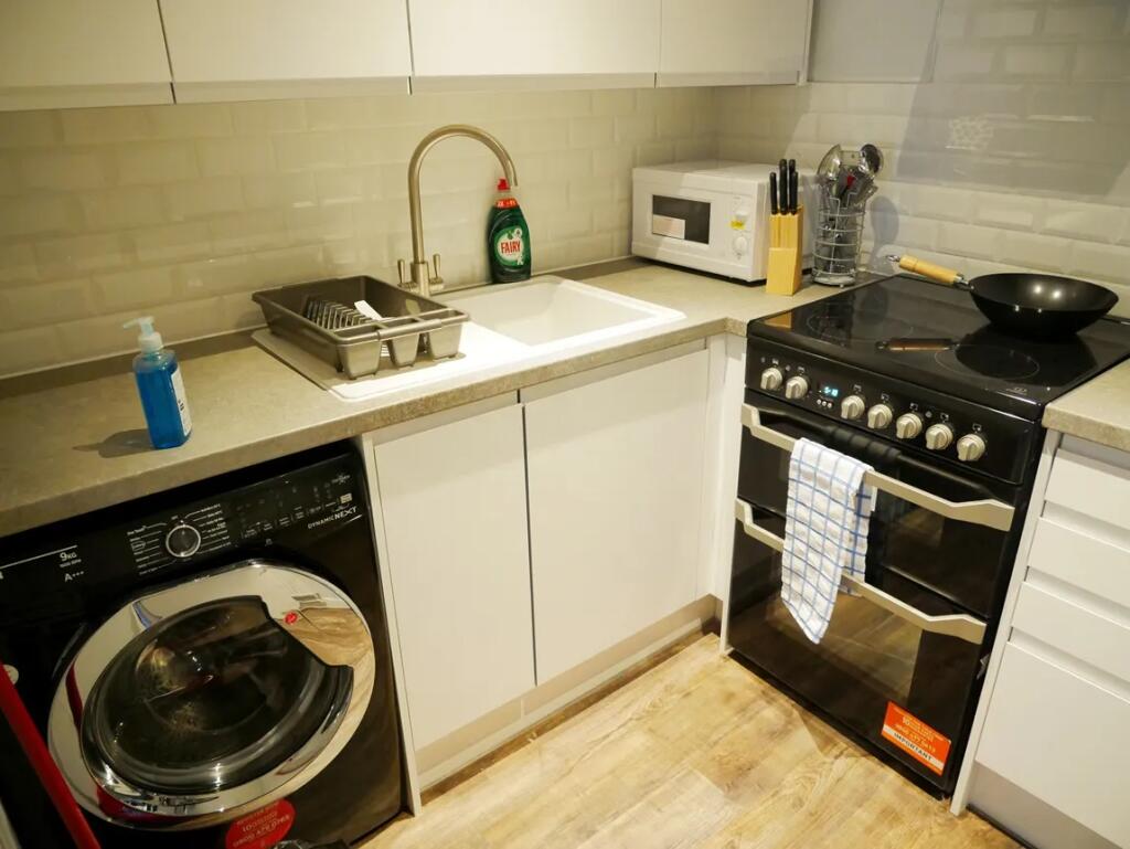 Modern kitchen area featuring a sleek black ele...