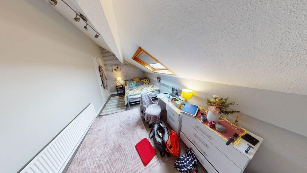 Cozy attic single bedroom with a sloped ceiling...