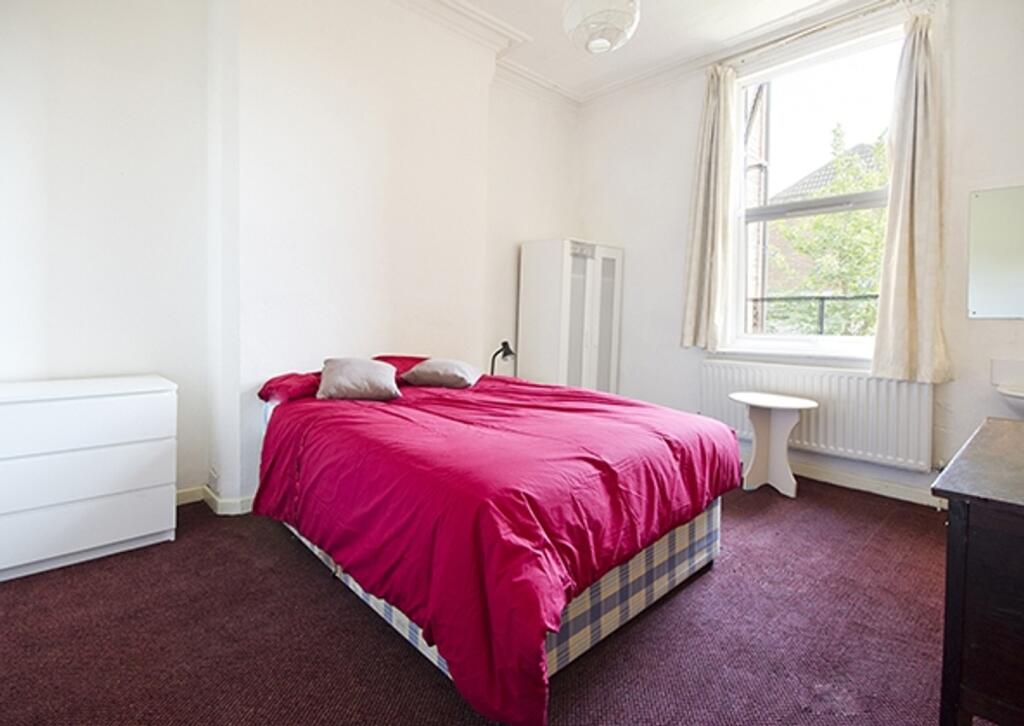 A bright and tidy double bedroom featuring natu...